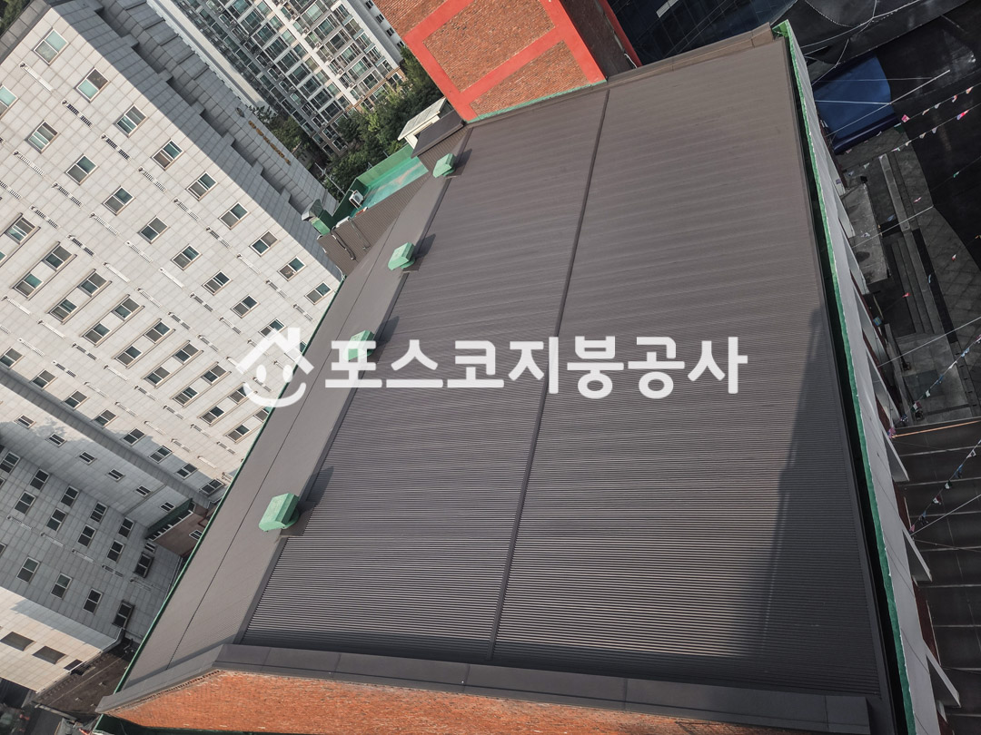 넓은 교회 지붕 전체를 회색 칼라강판으로 새로 덮은 모습